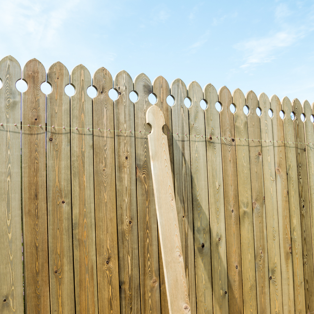 Homeowner inspecting a wood fence line in spring in an Ontario residential backyard — fence post and boundary check guide
