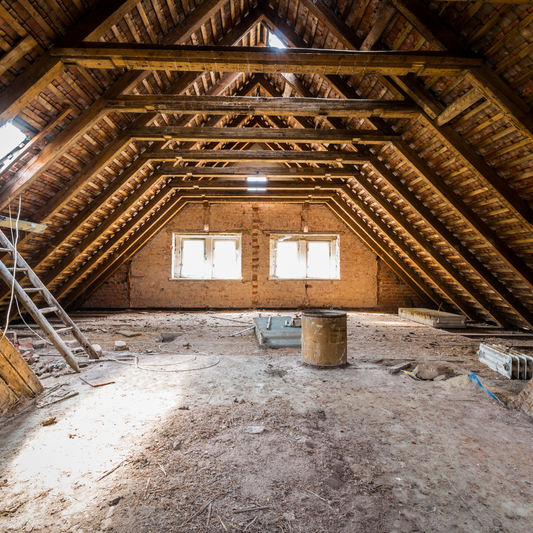 Homeowner inspecting attic insulation and roof rafters during spring home inspection in Ontario